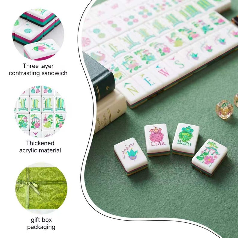 May include: A set of white acrylic mahjong tiles featuring colorful floral and character designs, including tiles labeled Joker, Crak, and Bam. The tiles have a three-layer contrasting sandwich edge and are presented with a green gift box.