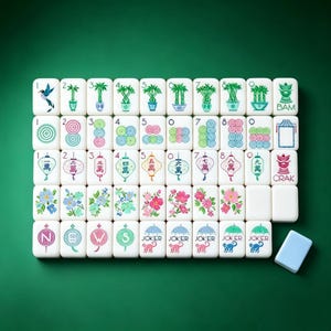 May include: A set of white mahjong tiles arranged in a grid, featuring colorful illustrations of bamboo, circles, Chinese characters, flowers, and monkeys. The tiles include text labels like BAM, CRAK, NEWS, and JOKER, with one plain light blue tile nearby.