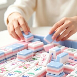 May include: A set of rectangular mahjong tiles featuring a pastel color palette of light blue, white, and soft pink. Each tile displays intricate illustrations including floral patterns, bamboo stalks, lanterns, and monkeys with the text JOKER.