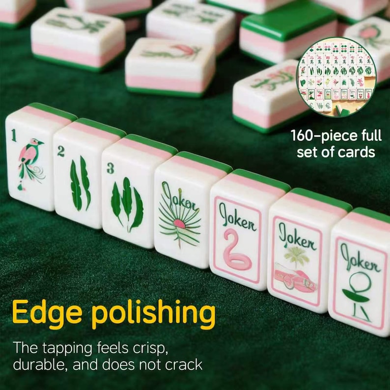 May include: A set of white mahjong tiles with pink and green accents, featuring numbered tiles from one to three, palm leaf illustrations, and tiles labeled Joker. The set includes 160 pieces with polished edges, displayed on a dark green surface.