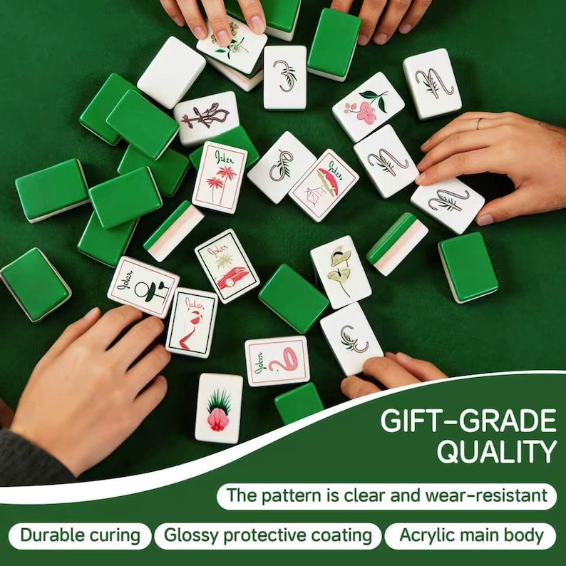 May include: A set of rectangular mahjong tiles with green backs and white faces featuring various black and colored illustrations including flowers, palm trees, and the word Joker. The text GIFT-GRADE QUALITY is printed on the image.