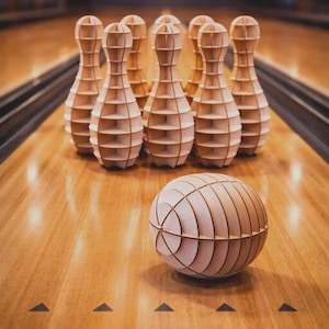 May include: Wooden bowling pins and ball set on a wooden lane. The pins are arranged in a triangle, with the ball in the foreground. The pins and ball are made of light-colored wood, and the lane has a glossy finish.