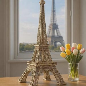 Peut inclure: Maquette en bois de la Tour Eiffel, riche en détails, posée sur une table en bois. Un bouquet de tulipes est à droite. La Tour Eiffel est visible à travers une fenêtre en arrière-plan.