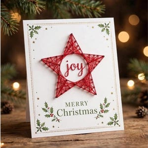 May include: A white greeting card featuring a red string art star at the center with the word joy written in red script inside. The card has a decorative border with green holly leaves and gold stars, and the text MERRY Christmas in green.