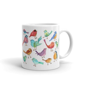 May include: White ceramic mug with a colorful watercolor design of various birds. The birds are painted in shades of blue, green, red, orange, yellow, and purple.