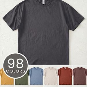 May include: A charcoal gray crew neck t-shirt. The shirt is displayed with a variety of color options, including mustard yellow, olive green, light blue, beige, rust, and brown. A circular graphic indicates 98 color options are available.
