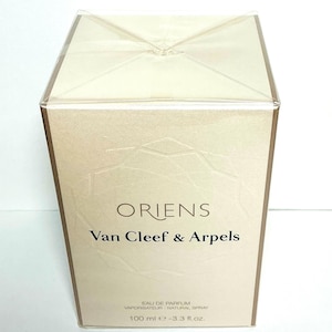 May include: A rectangular perfume box with the text "ORIENS Van Cleef & Arpels" in black. The box is beige with a geometric pattern and a clear plastic top. The box contains 3.3 fl oz of perfume.