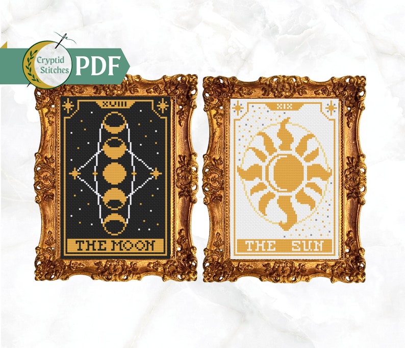 May include: Two framed cross-stitch patterns, one depicting the moon with phases in gold on a black background, and the other depicting the sun in gold on a white background. The frames are ornate gold.