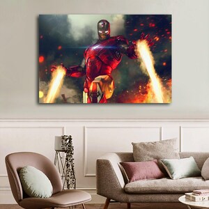 May include: A canvas print of Iron Man in a dynamic pose, clad in a red and gold armored suit. The artwork depicts Iron Man with energy beams emanating from his hands against a backdrop of fiery explosions and a smoky sky.
