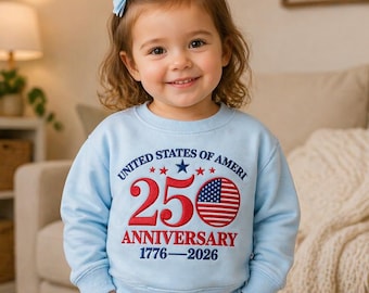 Könnte beinhalten: Hellblaues Sweatshirt mit dem Text "UNITED STATES OF AMERI" und "250 ANNIVERSARY 1776-2026" in Rot und Marineblau. Die Zahl 250 ist mit einem US-Flaggen-Design zentriert. Ein junges Kind trägt das Sweatshirt.