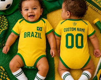 Könnte beinhalten: Zwei gelb-grüne Babybodys mit dem Text BRAZIL und CUSTOM NAME sowie der Nummer 00. Die Kleidungsstücke haben kurze Ärmel, grüne Säume und eine kleine Fußballgrafik. Die Säuglinge tragen weiße Socken mit grünen Fußballmustern an den Füßen.