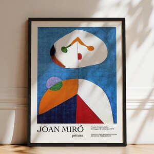 May include: A framed exhibition poster featuring an abstract Joan Miró painting with blue, white, orange, red, green, and purple shapes. The text reads JOAN MIRÓ, pittura, Firenze, Orsanmichele, 26 maggio-30 settembre 1979, COMITATO PER LE MANIFESTAZIONI.