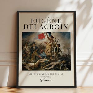 May include: A framed art print featuring Eugène Delacroix's painting Liberty Leading the People. The poster displays the iconic scene with a central figure holding a French flag, surrounded by figures in a landscape. Text includes the artist's name, the title, and Louvre Museum details.