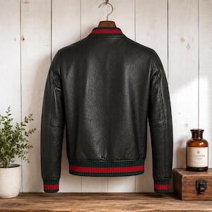 Front view of a model wearing a premium mens genuine leather jacket in textured black with vertical red and green Italian style stripes on the chest and sleeves.