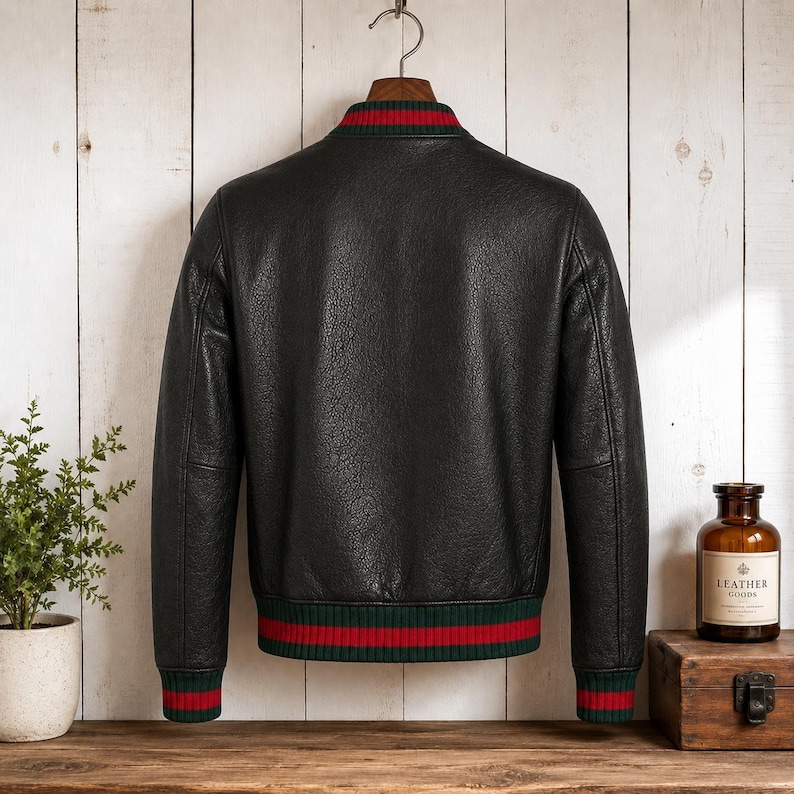 Front view of a model wearing a premium mens genuine leather jacket in textured black with vertical red and green Italian style stripes on the chest and sleeves.