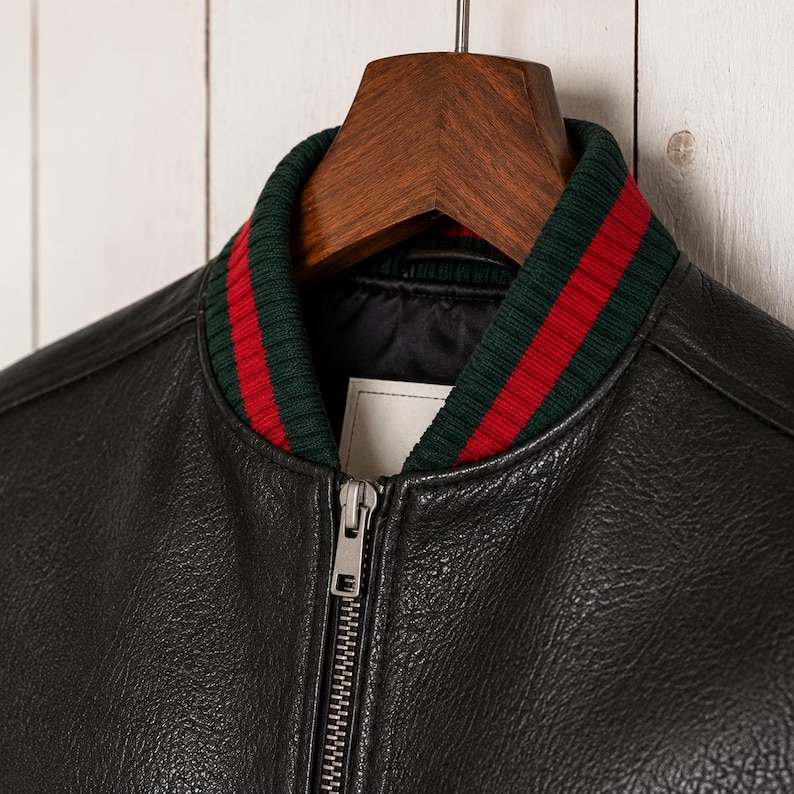 Front view of a model wearing a premium mens genuine leather jacket in textured black with vertical red and green Italian style stripes on the chest and sleeves.