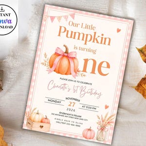 May include: A rectangular birthday invitation card featuring a light pink gingham border, a watercolor orange pumpkin with a pink bow, and text reading Our Little Pumpkin is turning one, Charlotte's 1st Birthday, November 27, 2026, at 3:00 PM.