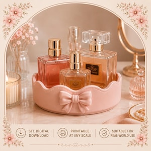 Peut inclure: Un plateau de vanité rond rose clair avec un nœud sculpté sur le devant, contenant trois flacons de parfum en verre avec des bouchons dorés. Le plateau a un bord festonné et est présenté avec du texte indiquant un téléchargement numérique STL.
