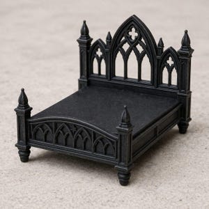May include: A miniature black bed with a gothic design. The bed frame features arched details and pointed finials. The headboard has a cross-shaped cutout. The bed is likely for a dollhouse or other miniature display.
