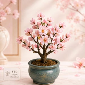 Peut inclure: Un arbre miniature en fleurs de cerisier avec des pétales rose clair et un tronc brun texturé, planté dans un pot en céramique rond bleu-vert marbré. Une petite étiquette carrée affiche le texte STL Digital Download avec une icône de fleur.