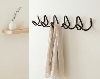Perchero de metal negro ondulado, colgador de pared escultural estilo Bauhaus, almacenamiento minimalista para la entrada.