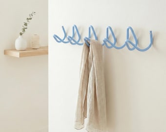 Perchero de metal ondulado azul claro, colgador de pared escultural estilo Bauhaus, organizador minimalista para la entrada.