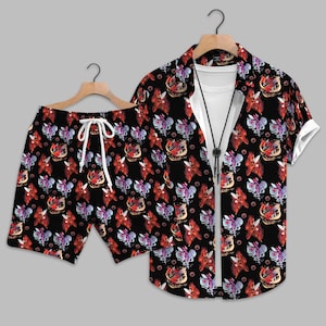 May include: A matching black short-sleeve button-down shirt and shorts set. The set features a repeating pattern of red, purple, and gold stylized floral designs. The shorts have a white drawstring. The shirt is paired with a white undershirt and a black bolo tie.