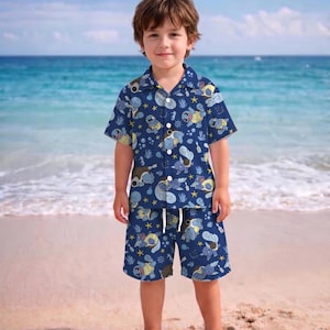 K&ouml;nnte beinhalten: Ein kurz&auml;rmeliges Hemd mit Knopfleiste und dazu passende Shorts in Marineblau, bedruckt mit hellblauen Cartoon-Schildkr&ouml;ten, gelben Seesternen und wei&szlig;en Blasen. Das Hemd verf&uuml;gt &uuml;ber einen Kragen und wei&szlig;e Kn&ouml;pfe auf der Vorderseite.