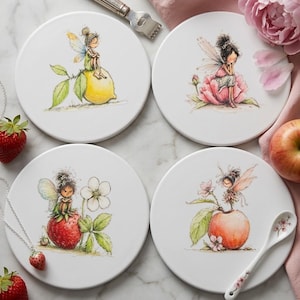 May include: A set of four round white ceramic coasters featuring watercolor-style illustrations of small fairies perched on a lemon, a pink flower, a strawberry, and a peach, accompanied by a silver-toned metal tool and a small ceramic spoon.