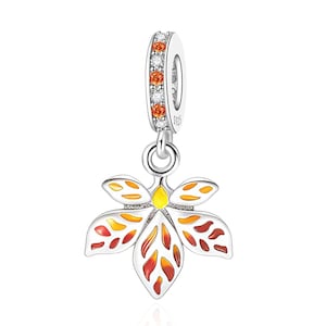 Può includere: Un ciondolo in argento con un design a fiore a cinque petali con inserti in smalto giallo, arancione e rosso. La contromaglia è incastonata con pietre alternate chiare e arancioni ed è marchiata S925 per indicare la composizione in argento.