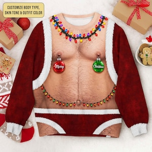 May include: A long-sleeve sweatshirt featuring a realistic print of a bare, hairy chest decorated with a string of colourful Christmas lights, two hanging ornaments labelled Merry and Christmas, and red fabric trim resembling a Santa Claus suit.