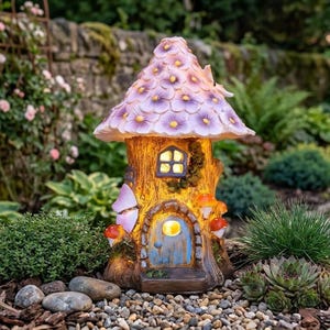 May include: A charming fairy house garden ornament. The mushroom-shaped house features a purple flower-covered roof and a blue door. The interior emits a warm glow, and the house is set amongst plants and small stones.