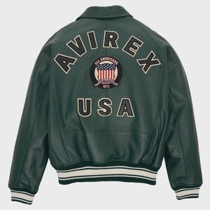 May include: A dark green leather jacket with the word "AVIREX" arched across the shoulders. Below is a patch with the American flag and the words "ALL AMERICANS ESTABLISHED 1975". The word "USA" is below the patch. The jacket has white and green striped cuffs and hem.