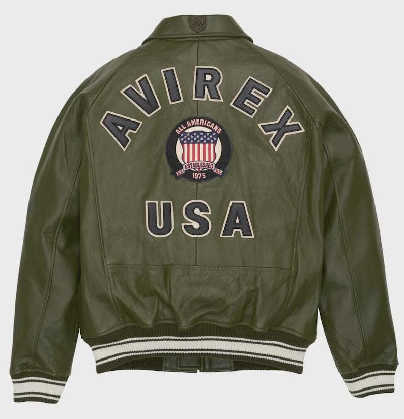 May include: Olive green leather jacket with the word "AVIREX" arched across the back, above a circular patch with the American flag and the words "ALL AMERICANS ESTABLISHED 1975". The word "USA" is below the patch. The jacket has white and black striped cuffs.
