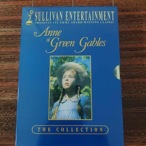 May include: A blue rectangular box set titled Sullivan Entertainment Presents Its Emmy Award-Winning Classic Anne of Green Gables The Collection. The cover features a central photograph of a young person wearing a straw hat and braids.