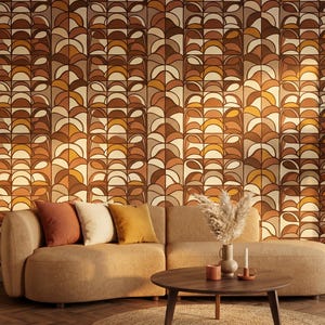 May include: A living room scene featuring a curved beige sofa with three throw pillows in shades of brown and yellow. A round wooden coffee table sits on a jute rug. The wall is decorated with a retro-style wallpaper in brown, orange, and beige tones.