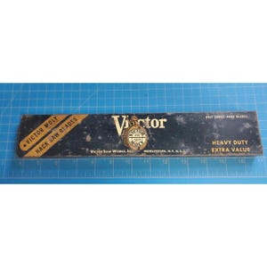 Puede incluir: Una caja rectangular negra y amarilla para hojas de sierra para metales Victor Moly. La caja presenta el texto Victor Saw Works, Inc., Middletown, N.Y., U.S.A., Half Gross Hand Blades, Heavy Duty y Extra Value. Una regla muestra 43,18 cm.