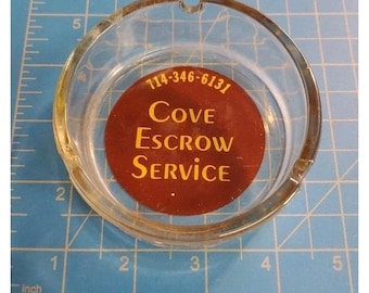 Anuncio de Cove Escrow Co. Cenicero transparente