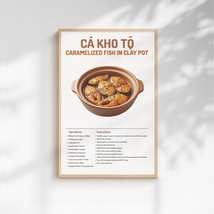 Puede incluir: Un póster enmarcado con el título "CÁ KHO TÔ - Pescado caramelizado en olla de barro" sobre una imagen del plato en una olla de barro marrón. El póster incluye una lista de ingredientes e instrucciones.