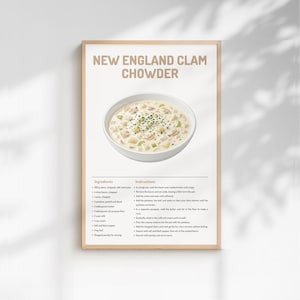 Puede incluir: Un póster enmarcado con una receta de New England Clam Chowder. La imagen muestra un cuenco de sopa cremosa adornada con hierbas. La receta incluye ingredientes e instrucciones, con el título en letras grandes y en negrita.