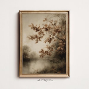 May include: A framed wall art print featuring a landscape painting of a calm river with overhanging oak branches in shades of brown and beige. The artwork is enclosed in a metallic gold frame and includes the text AESTIQUEA at the bottom centre.