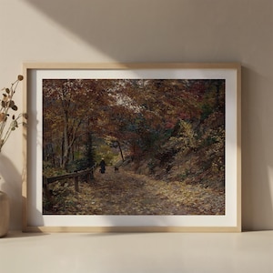Puede incluir: Un cuadro de paisaje enmarcado que muestra un sendero cubierto de hojas de oto&ntilde;o, bordeado por &aacute;rboles con follaje naranja, marr&oacute;n y amarillo. Una peque&ntilde;a figura y un perro caminan por el sendero, delimitado por una valla de madera.