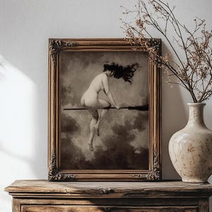 May include: A framed wall art print featuring a sepia-toned illustration of a figure with long dark hair riding a broomstick through a cloudy sky. The artwork is enclosed in an ornate, dark brown wooden frame with intricate carved detailing.