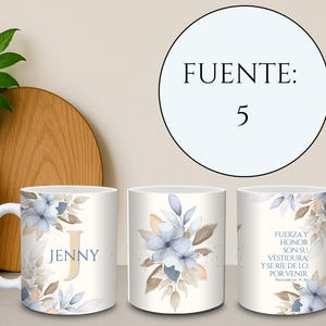 May include: White ceramic mug featuring a floral design with blue and tan accents. The mug has the name "JENNY" and the letter "J" printed on it. The mug also has text in Spanish. A decorative and functional item.