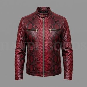 May include: A red and black snakeskin patterned jacket featuring a stand-up collar with a single snap button, a full-length central zipper, and two horizontal zippered chest pockets. The long-sleeved garment has a structured fit and texture.