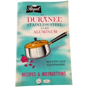 Può includere: Libretto di ricette e istruzioni per la cucina Regal vintage. La copertina presenta un'illustrazione di una casseruola in acciaio inossidabile e dorata. Il testo include "Duranel Stainless Steel Clad Aluminum" e "Waterless Cookware".