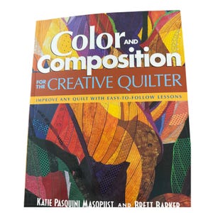 May include: A book titled Color and Composition for the Creative Quilter by Katie Pasquini Masopust and Brett Barker. The cover features a vibrant, abstract quilt pattern with orange, yellow, purple, and green fabric textures and stitching.