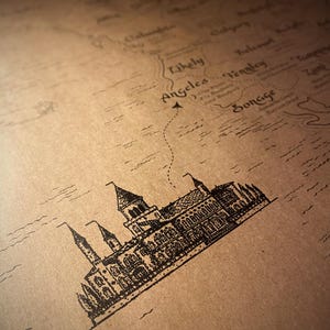 May include: A detailed map illustration with a vintage aesthetic. The map features a castle drawing and the word "Angeles" with a dotted line. The map is printed on a tan paper.