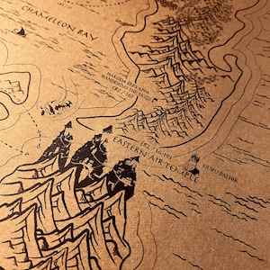 May include: A detailed map with black ink illustrations on a tan background. The map features geographical elements, text including "Chameleon Bay" and "Eastern Air Temple", and the phrase "Hakoda sees Appa wandering the skies".