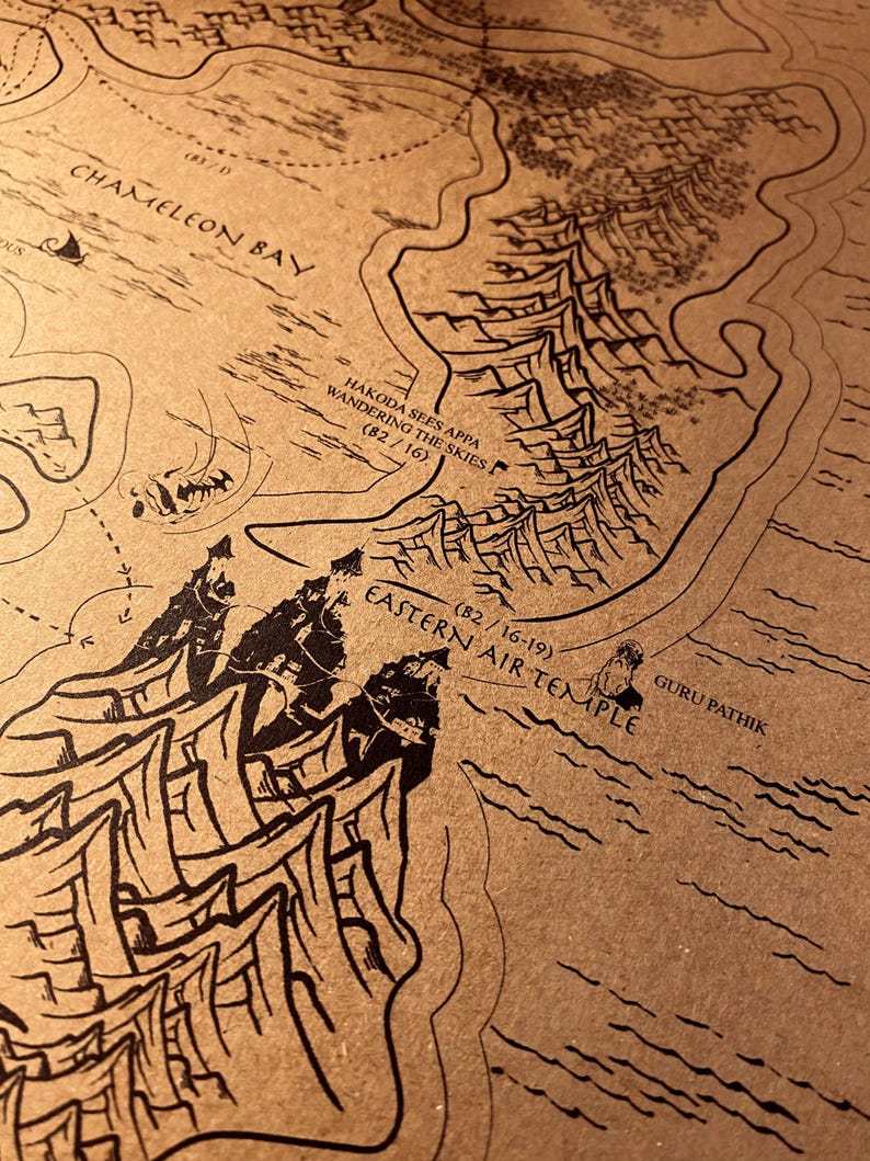 May include: A detailed map with black ink illustrations on a tan background. The map features geographical elements, text including "Chameleon Bay" and "Eastern Air Temple", and the phrase "Hakoda sees Appa wandering the skies".